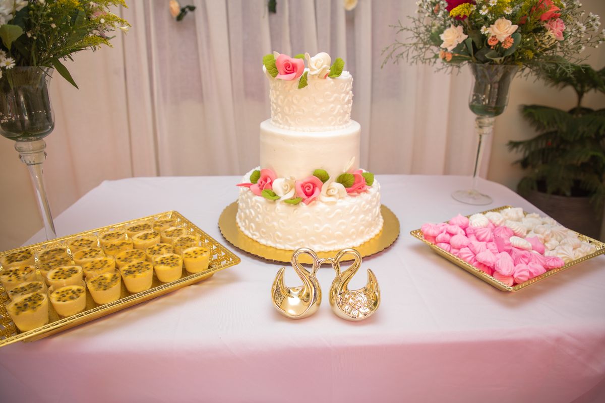 Beautiful wedding cake with floral decorations, surrounded by desserts on an elegant table setting. Licensed inspiration image; not a BMG client portfolio claim.