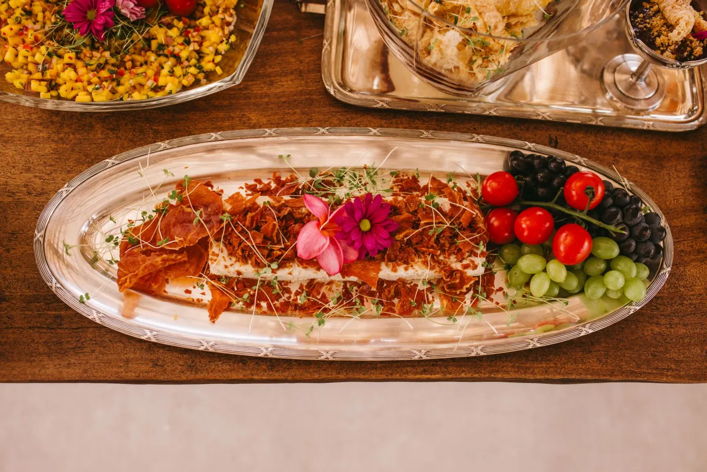 Luxury wedding food plating with fresh fruits, flowers, and decorative elements for a stylish event. Licensed inspiration image; not a BMG client portfolio claim.